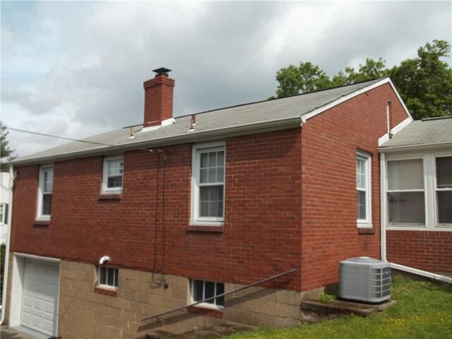 109 Mason Dr, Shaler, PA 15116 - view of side of property with cooling unit, a chimney, brick siding, and an attached garage