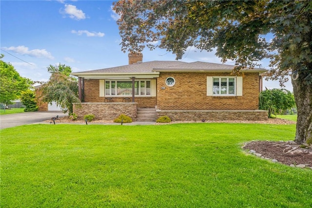 621 Kimlyn Ave, North Huntingdon, PA 15642 - view of front of house featuring a front yard, a chimney, and brick siding