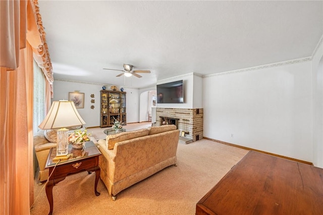 621 Kimlyn Ave, North Huntingdon, PA 15642 - living room featuring a ceiling fan, a fireplace, light carpet, ornamental molding, and baseboards