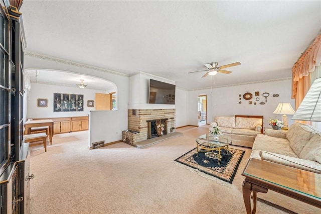 621 Kimlyn Ave, North Huntingdon, PA 15642 - carpeted living room with a ceiling fan, a stone fireplace, arched walkways, and crown molding