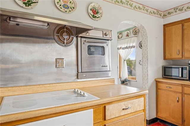 621 Kimlyn Ave, North Huntingdon, PA 15642 - kitchen featuring appliances with stainless steel finishes, light countertops, arched walkways, and brown cabinetry