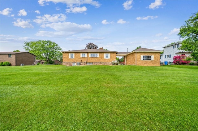 621 Kimlyn Ave, North Huntingdon, PA 15642 - rear view of house featuring a yard, a chimney, and brick siding