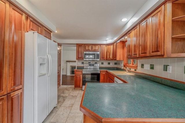 200 Spartan Dr, Bethel Park, PA 15102 - kitchen featuring stainless steel appliances, a sink, brown cabinets, recessed lighting, and decorative backsplash