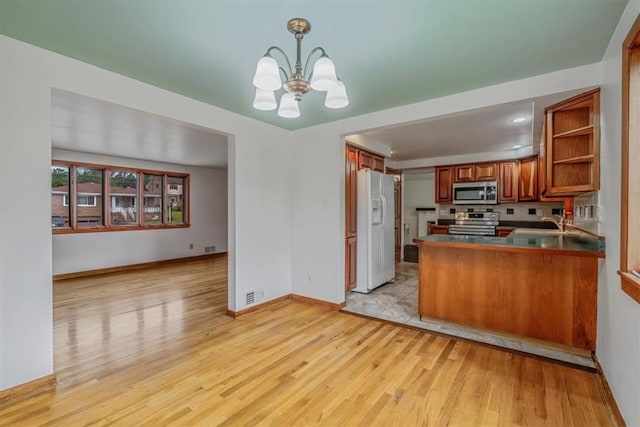 200 Spartan Dr, Bethel Park, PA 15102 - kitchen featuring stainless steel appliances, a chandelier, light wood finished floors, brown cabinets, and open shelves