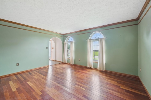 5020 Meadow Crest Dr, Hampton, PA 15101 - unfurnished room featuring arched walkways, wood-type flooring, crown molding, a textured ceiling, and baseboards