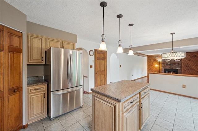5020 Meadow Crest Dr, Hampton, PA 15101 - kitchen with freestanding refrigerator, arched walkways, a brick fireplace, light tile patterned floors, and wooden walls