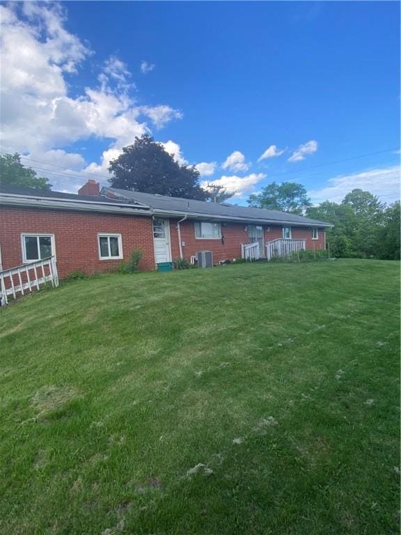 945 Brodhead Rd, Moon/Crescent Twp, PA 15108 - back of property with brick siding, a yard, and a chimney