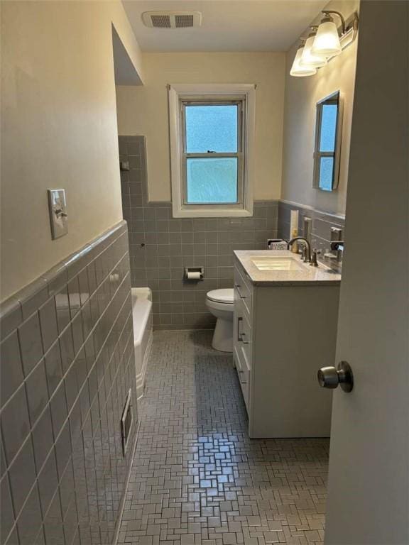 1123 Blue Jay Dr, Pittsburgh, PA 15243 - bathroom featuring vanity, tile walls, toilet, wainscoting, and a bathtub