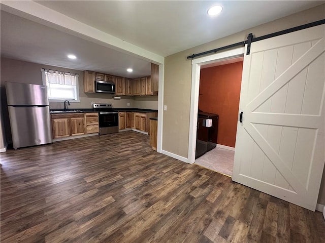 1081 Dixon Rd, Cherryhll Twp/Clymer, PA 15728 - kitchen featuring appliances with stainless steel finishes, dark countertops, a sink, a barn door, and dark wood-style flooring