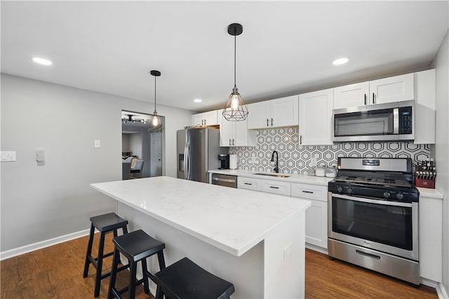 848 7th St, Verona, PA 15147 - kitchen featuring appliances with stainless steel finishes, a sink, a center island, backsplash, and white cabinetry