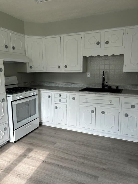 273 Albert St, Mt Washington, PA 15211 - kitchen with stainless steel stove, a sink, white cabinets, under cabinet range hood, and tasteful backsplash