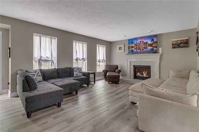6023 Hawthorn Dr, Moon/Crescent Twp, PA 15108 - living room with a glass covered fireplace, light wood-style floors, a textured ceiling, and baseboards