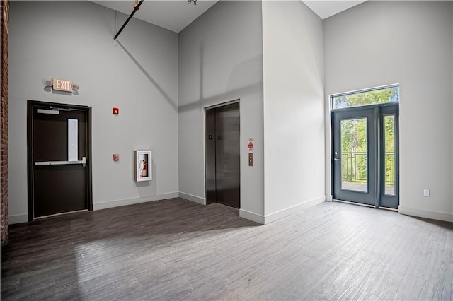 622 Gross St Unit 104, Bloomfield, PA 15224 - foyer entrance featuring a high ceiling, elevator, wood finished floors, and baseboards