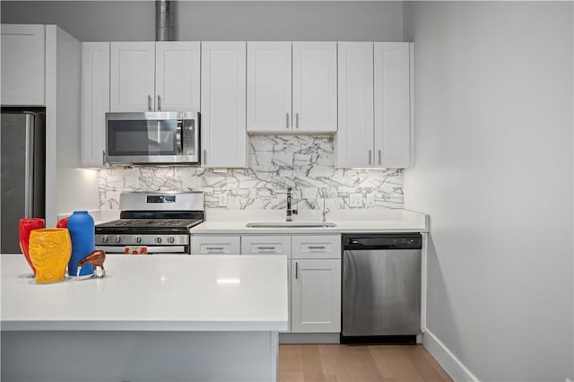 622 Gross St Unit 104, Bloomfield, PA 15224 - kitchen featuring appliances with stainless steel finishes, a sink, tasteful backsplash, and light countertops