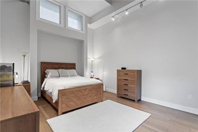 622 Gross St Unit 104, Bloomfield, PA 15224 - bedroom with a high ceiling, light wood finished floors, rail lighting, and baseboards