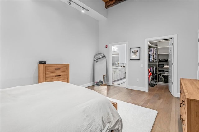 622 Gross St Unit 104, Bloomfield, PA 15224 - bedroom with a high ceiling, light wood finished floors, a walk in closet, a closet, and connected bathroom