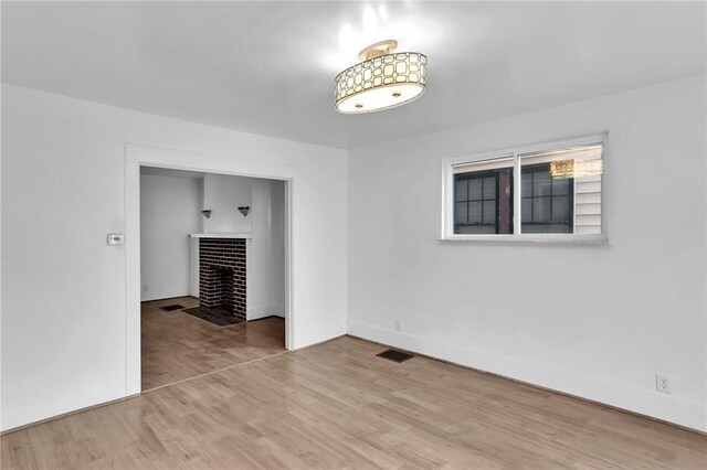 623 E 3rd Ave, Tarentum, PA 15084 - unfurnished room featuring a fireplace with flush hearth, wood finished floors, and baseboards