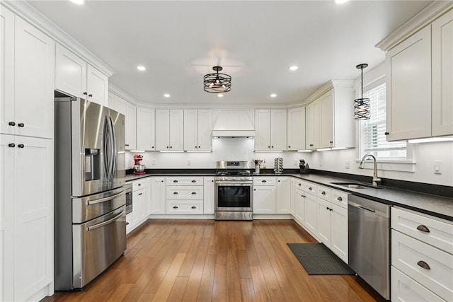 914 James St, East Allegheny, PA 15212 - kitchen featuring appliances with stainless steel finishes, premium range hood, a sink, dark countertops, and white cabinets