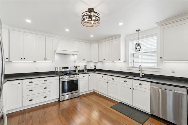 914 James St, East Allegheny, PA 15212 - kitchen with stainless steel appliances, custom range hood, dark countertops, and recessed lighting