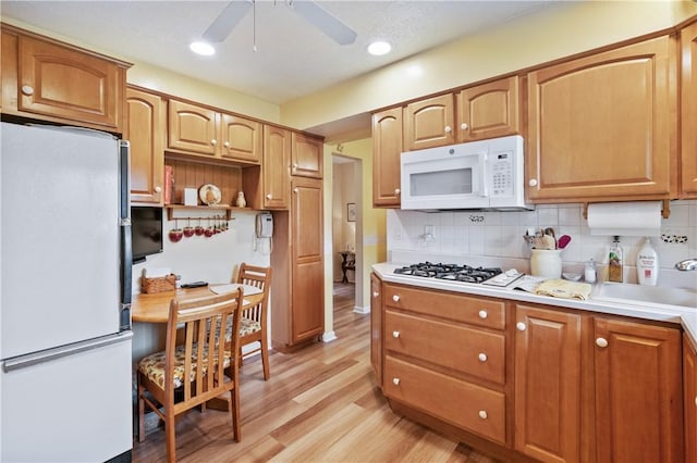 407 Neola Cir, Ross Twp, PA 15237 - kitchen featuring white appliances, a ceiling fan, light wood-style floors, light countertops, and decorative backsplash
