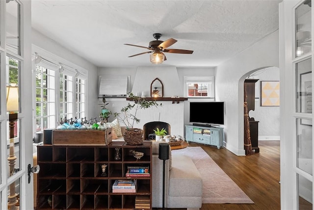 1437 Browning Rd, Highland Park, PA 15206 - living room featuring plenty of natural light, arched walkways, ceiling fan, wood finished floors, and a textured ceiling