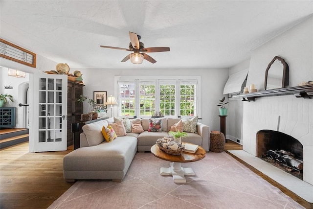1437 Browning Rd, Highland Park, PA 15206 - living area with wood finished floors, a ceiling fan, and a fireplace with flush hearth