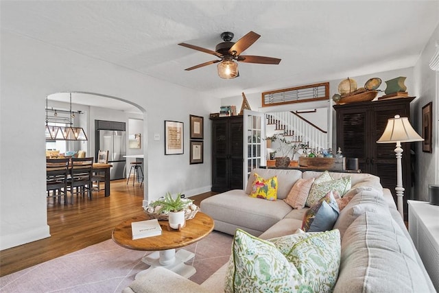 1437 Browning Rd, Highland Park, PA 15206 - living room with arched walkways, a ceiling fan, stairway, wood finished floors, and baseboards