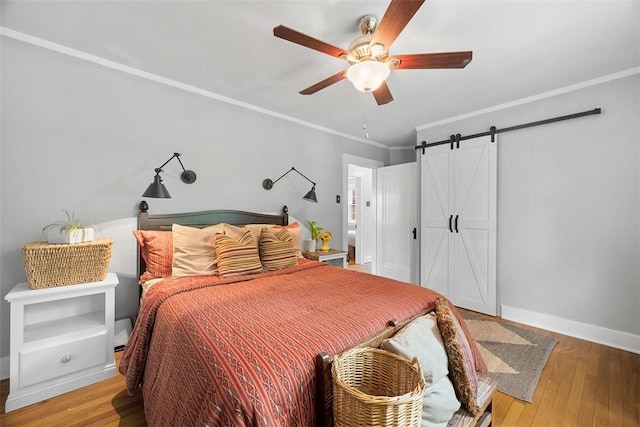 1437 Browning Rd, Highland Park, PA 15206 - bedroom with a barn door, hardwood / wood-style floors, crown molding, ceiling fan, and baseboards