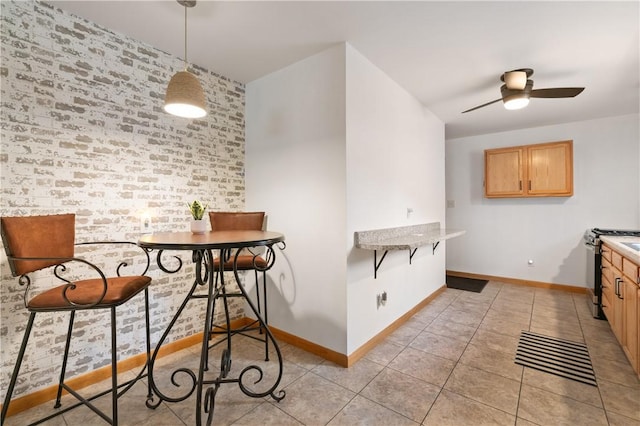 3261 Central Ave, Brighton Heights, PA 15212 - dining space with baseboards, light tile patterned flooring, a ceiling fan, and brick wall