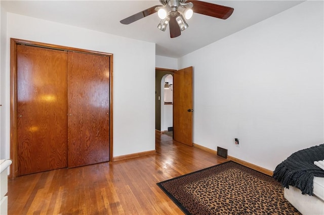 3261 Central Ave, Brighton Heights, PA 15212 - bedroom featuring wood finished floors, baseboards, arched walkways, a closet, and a ceiling fan