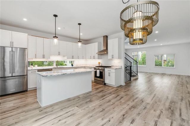 5523 Butler St, Lawrenceville, PA 15201 - kitchen with stainless steel appliances, wall chimney range hood, a sink, a center island, and a chandelier