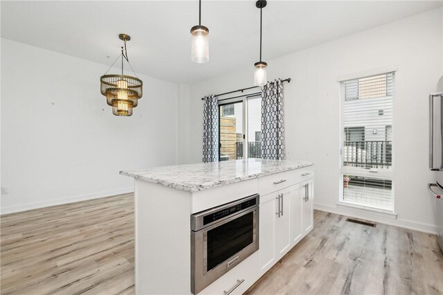 5523 Butler St, Lawrenceville, PA 15201 - kitchen featuring light wood finished floors, pendant lighting, white cabinetry, and light stone countertops