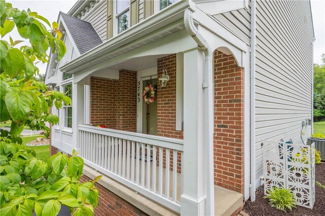 5743 Villahaven Dr, Bethel Park, PA 15236 - view of side of property with brick siding, covered porch, a shingled roof, and central AC unit