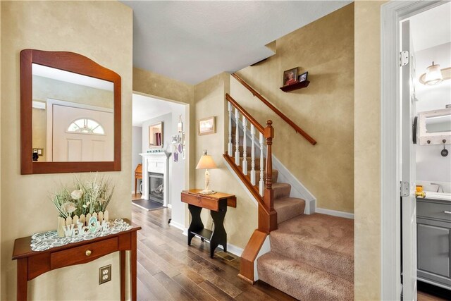 5743 Villahaven Dr, Bethel Park, PA 15236 - entrance foyer with stairs, dark wood-style flooring, baseboards, and a fireplace with raised hearth