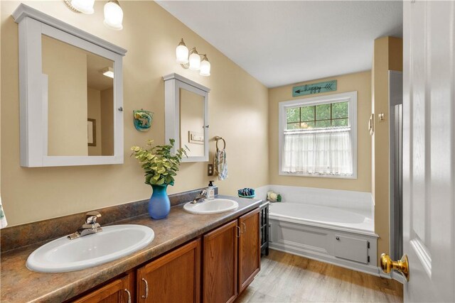 5743 Villahaven Dr, Bethel Park, PA 15236 - full bathroom featuring double vanity, a bath, and wood finished floors