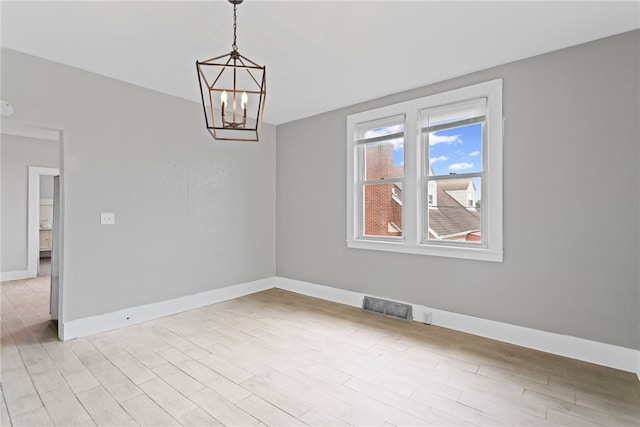 1222 Forest Ave, New Kensington, PA 15068 - spare room with baseboards, a chandelier, and light wood-style floors