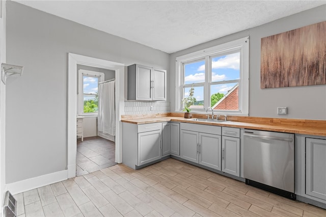1222 Forest Ave, New Kensington, PA 15068 - kitchen featuring stainless steel dishwasher, gray cabinetry, and wooden counters