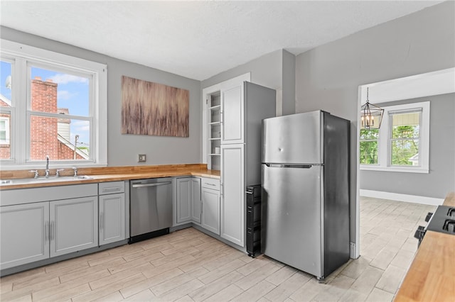 1222 Forest Ave, New Kensington, PA 15068 - kitchen with stainless steel appliances, gray cabinets, a sink, and wood counters