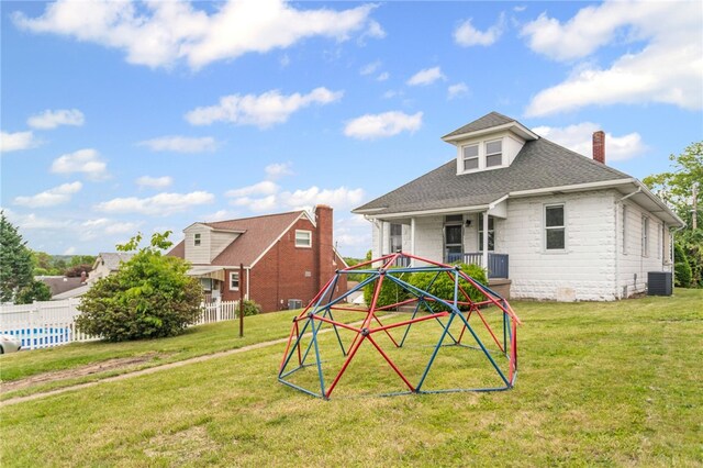 1222 Forest Ave, New Kensington, PA 15068 - rear view of property with central AC unit, a chimney, a yard, stone siding, and roof with shingles