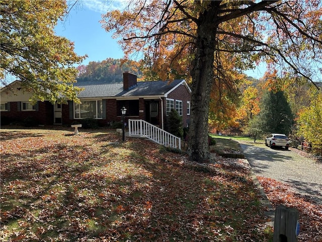 1877 Main St, Arona, PA 15617 - ranch-style home featuring a chimney, brick siding, and gravel driveway