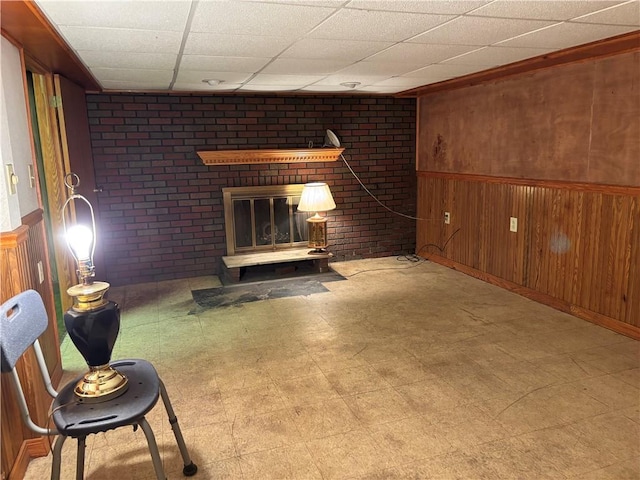 1877 Main St, Arona, PA 15617 - unfurnished living room with tile patterned floors, wooden walls, a drop ceiling, and wainscoting