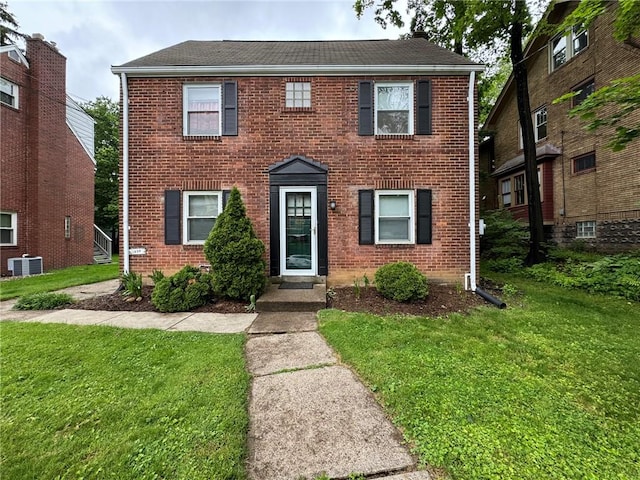 1022-1024 S Trenton Ave, Regent Square, PA 15221 - colonial-style house featuring a front yard, brick siding, central AC, and roof with shingles