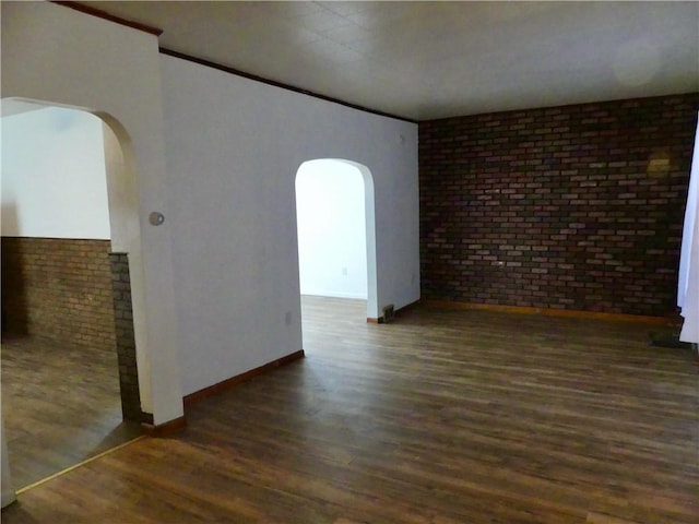 1112 Wade St, Aliquippa, PA 15001 - spare room with arched walkways, wood finished floors, baseboards, and brick wall