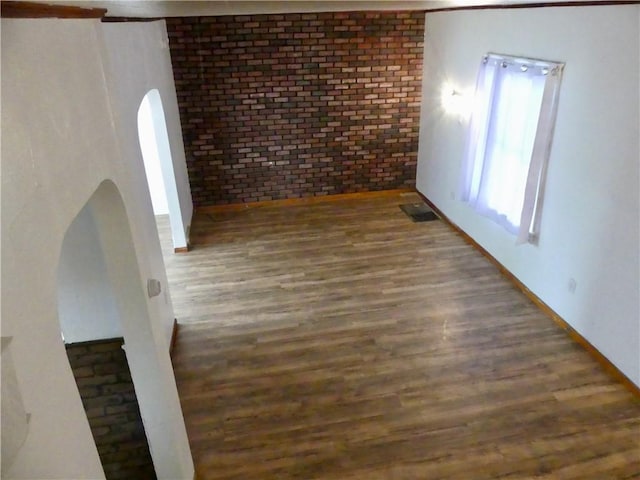 1112 Wade St, Aliquippa, PA 15001 - unfurnished room with arched walkways, wood finished floors, and brick wall