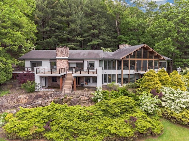 428 Jefferson School Rd, Cook Twp, PA 15658 - rear view of property with a sunroom, a chimney, stairs, a deck, and a wooded view