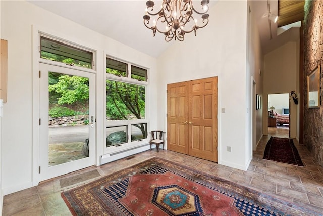 428 Jefferson School Rd, Cook Twp, PA 15658 - entrance foyer featuring baseboard heating, stone tile floors, a chandelier, baseboards, and high vaulted ceiling