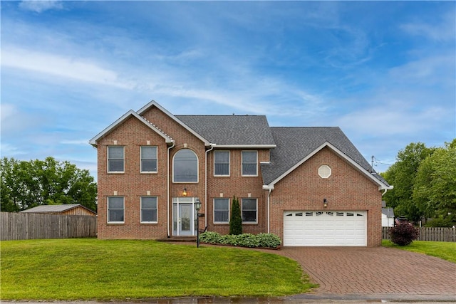 704 Park Ave, Rostraver, PA 15012 - colonial house featuring decorative driveway, a garage, and brick siding
