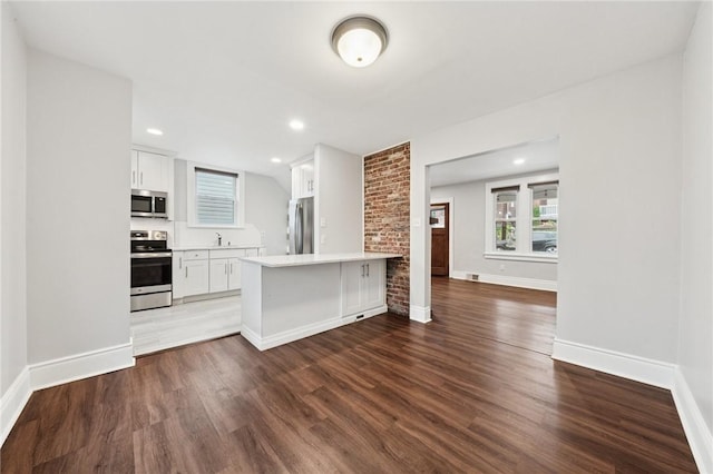 1110 Illinois Ave, Dormont, PA 15216 - kitchen featuring appliances with stainless steel finishes, wood finished floors, a peninsula, light countertops, and recessed lighting