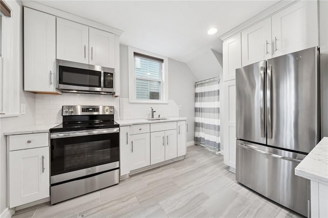1110 Illinois Ave, Dormont, PA 15216 - kitchen featuring stainless steel appliances, a sink, white cabinetry, backsplash, and lofted ceiling