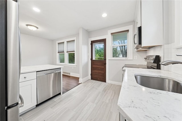1110 Illinois Ave, Dormont, PA 15216 - kitchen featuring appliances with stainless steel finishes, a sink, white cabinets, light stone counters, and recessed lighting